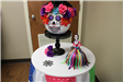Pumpkin decorated as sugar skull with catrina skeleton figurine