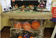 A city diorama with large pumpkins stacked beneath. One large pumpkin has City of Victoria logo