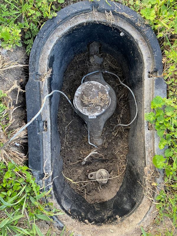 An open water meter box showing the inner workings