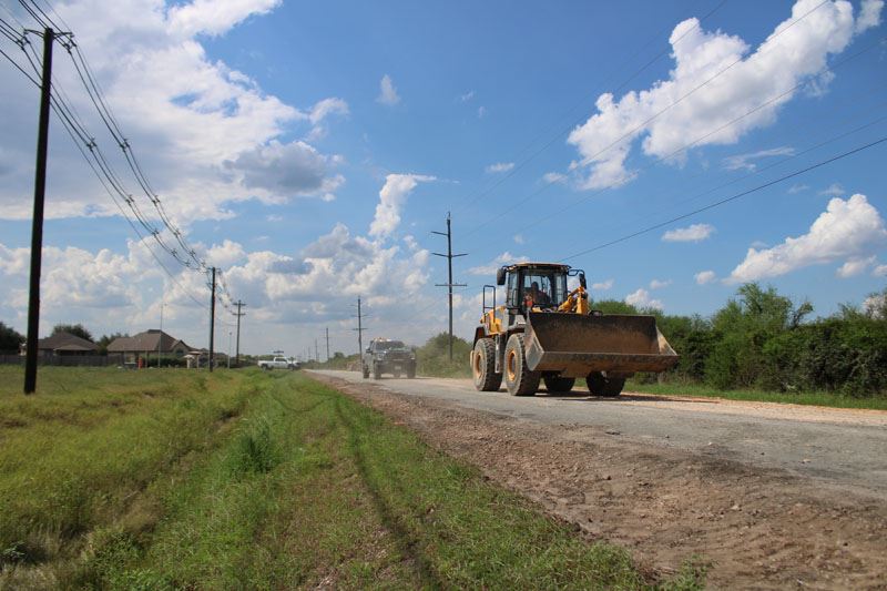 Heavy equipment rolling down a rough road