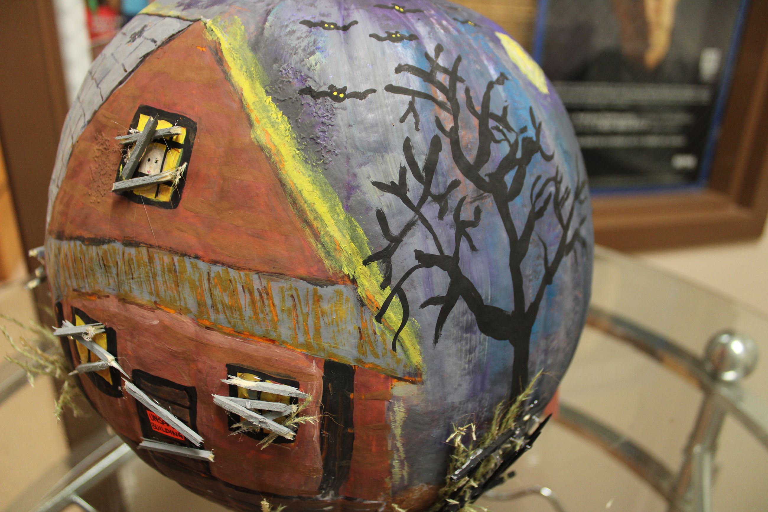 Seen from the back, dark-painted pumpkin with an orange 