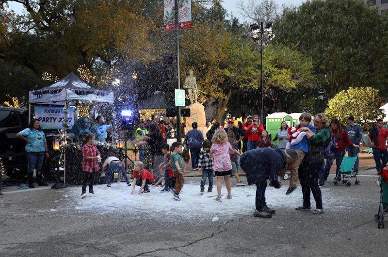 A Foamed Up booth shoots a white snowlike substance through the air onto the ground for kids